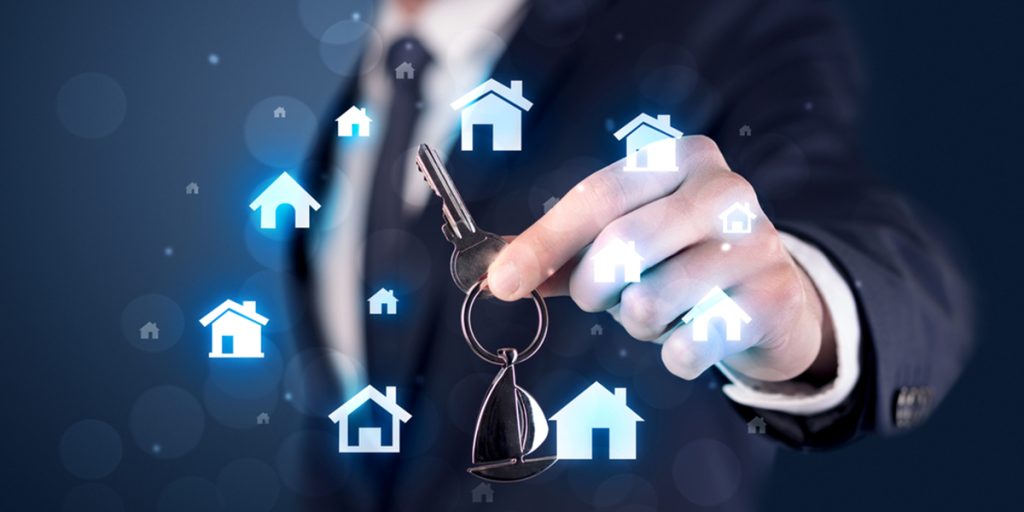 businessman holding keys with houses around